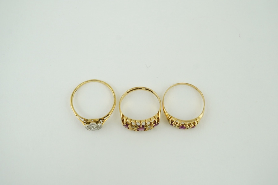 Two early 20th century yellow metal, ruby and diamond cluster set half hoop rings, one hallmarked 18ct gold and an 18ct and diamond cluster set ring, gross weight 7.1 grams. Condition - poor to fair